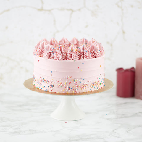 Roze taart met lijnen en gekleurde hageltjes